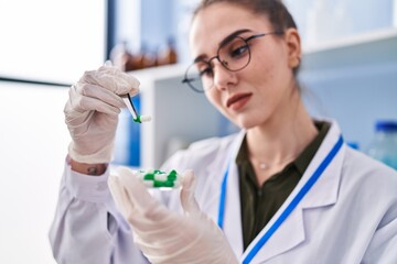 Young woman scientist holding pills at laboratory