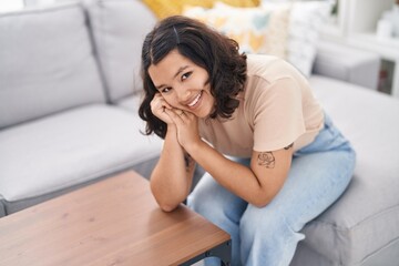 Young woman smiling confident sitting on sofa at home