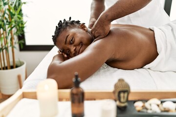 Obraz na płótnie Canvas African american woman reciving back massage at the clinic.
