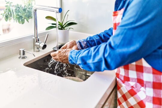 Senior Man Washing Hands At Kitchen