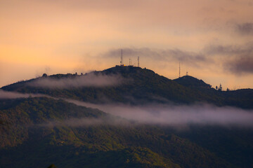 sunrise in the mountains with clouds and communication towers