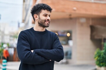 Young arab man smiling confident standing with arms crossed gesture at street