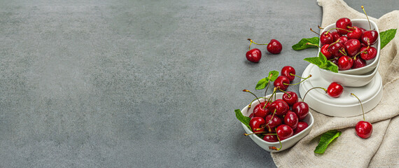 Ripe sweet cherries with fresh mint leaves, traditional summer fruits. Trendy stands, vintage napkin