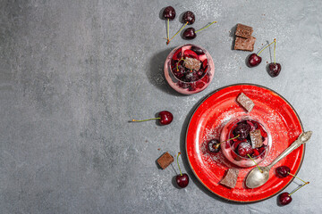 Delicious Italian dessert panna cotta with sweet cherry sauce, fresh berries and chocolate