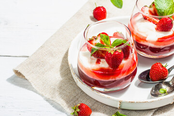 Italian dessert panna cotta in glass with strawberries. Healthy sweet food, hard light, dark shadow