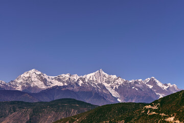 rolling mountains of meili range under blue sky