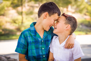 Fototapeta premium Outdoor portrait of mixed race Chinese and Caucasian brothers having fun.