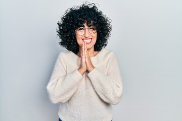 Fototapeta na wymiar Young middle east woman wearing casual white tshirt praying with hands together asking for forgiveness smiling confident.