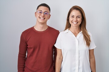 Mother and son standing together over isolated background with a happy and cool smile on face. lucky person.