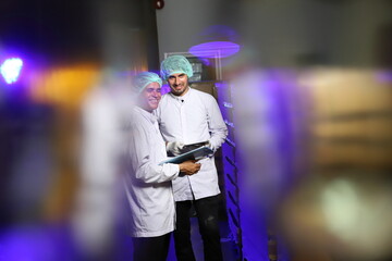 Fototapeta na wymiar Factory worker inspecting production line of drink production in factory , Concept of food industry