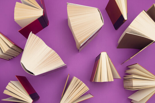 Creative pattern made of books on bright purple background. Education and  knowledge concept. Flat lay.