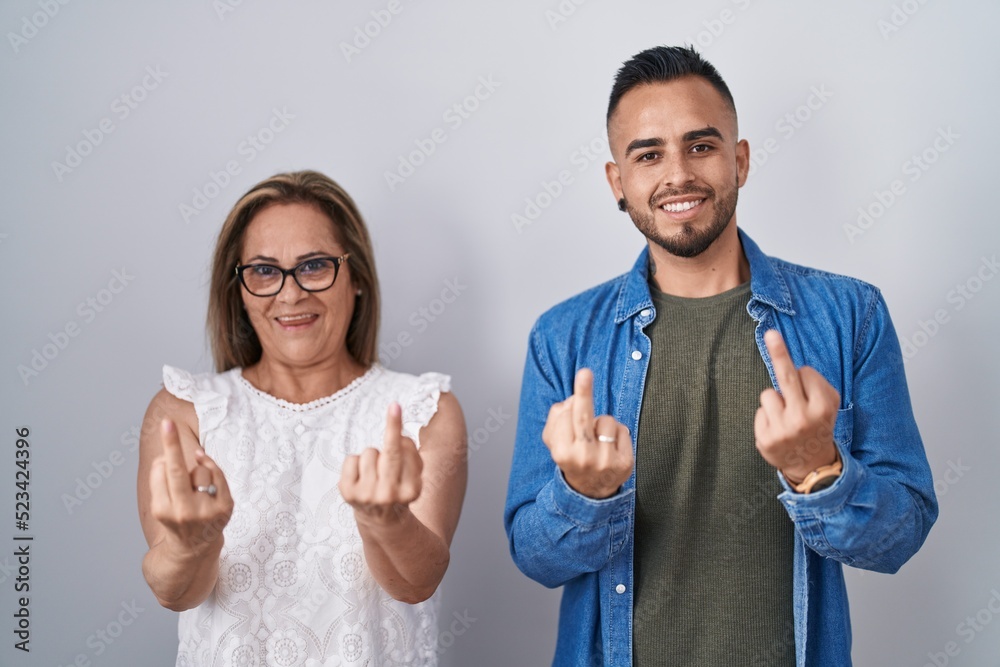 Poster hispanic mother and son standing together showing middle finger doing fuck you bad expression, provo