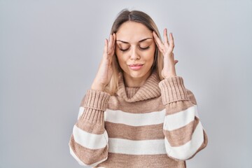 Young blonde woman wearing turtleneck sweater over isolated background with hand on head, headache...