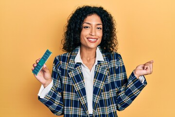 Young latin girl holding computer ram screaming proud, celebrating victory and success very excited...