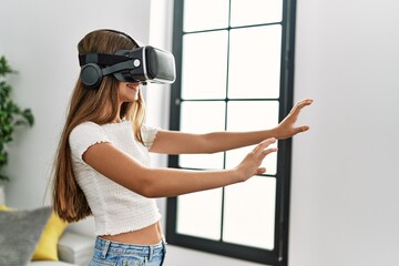 Adorable girl playing video game using vr goggles at home
