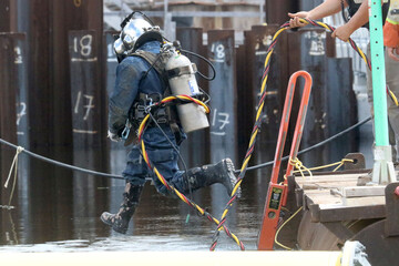 geared up to do underwater welding on construction project to build new dam, jumping in water