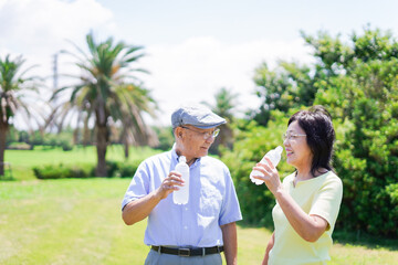 Old couple drinking water outside