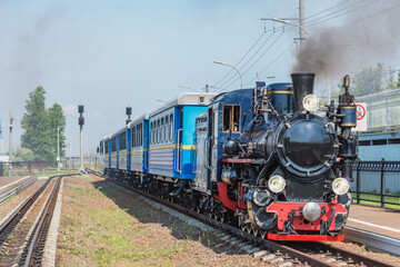 Fototapeta na wymiar Steam train of Children's railway stands by the platform. Saint Petersburg.