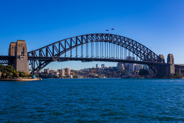 Fototapeta na wymiar 朝のオーストラリア・シドニーで、オペラハウス近くから見たハーバーブリッジ周辺の風景と青空