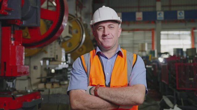 Portrait adult caucasian smile and is happy in a factory. Close-up of Professional Heavy Industry Engineer wearing a helmet. Men are 48-year-old.