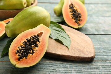 Fresh ripe papaya fruits on wooden table. Space for text