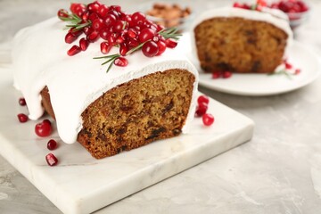 Fototapeta na wymiar Traditional classic Christmas cake decorated with cranberries, pomegranate seeds and rosemary on light table