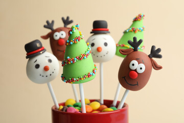 Delicious Christmas themed cake pops on beige background, closeup