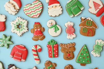 Fototapeta na wymiar Different Christmas gingerbread cookies on light blue background, flat lay