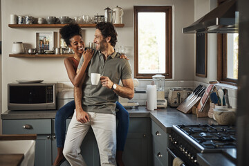 Happy, in love and laughing while an interracial couple enjoys morning coffee and bonding while...