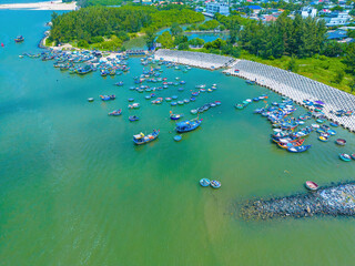 Beautiful blue skyline panoramic in Loc An Canal. Scenery landscape of fishing port with tsunami protection concrete blocks. Cityscape and boats in the sea. Loc An village near Vung Tau City.