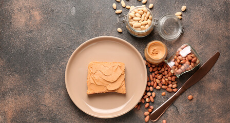Plate with tasty peanut butter and bread on grey background with space for text