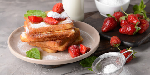 Plate with tasty French toasts and strawberry on grunge background
