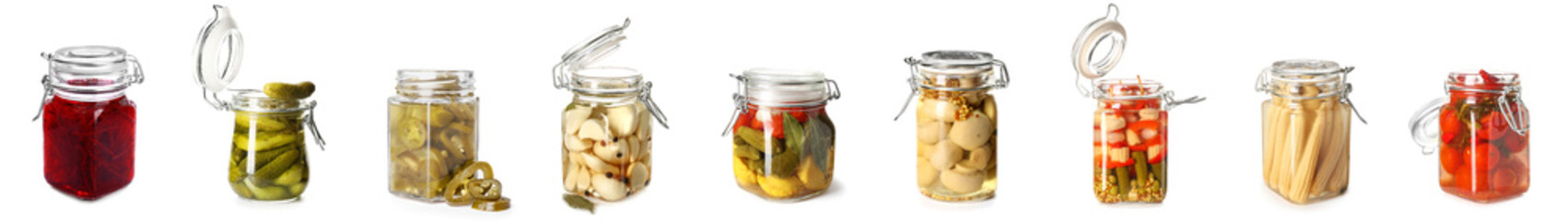 Collection of jars with canned vegetables on white background