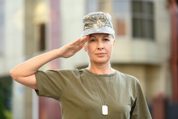 Mature female soldier saluting outdoors