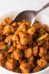 close-up of soy meat dish with a spoon in the background, vegetarian curry made with soya bean nuggets or chunks and spices, protein rich food, soft-focus with copy space