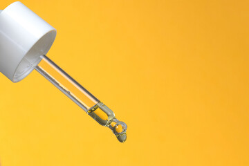 Serum dropper on a yellow background. Beauty. Facial Oil. Copy space. 