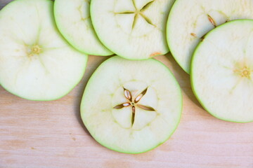 Heap of cutting into thin slices apples for cooking and preparing close up on wooden board. Top...