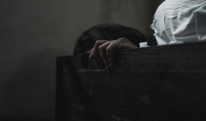 Horror ghost woman. Asian ghost horror creepy scary have hair covering face and eye lying in the old treasure chest, female makeup terror zombie face, murder, Closeup hand, Happy Halloween day concept