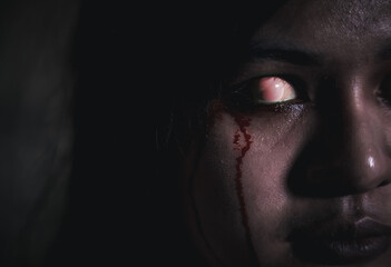 Bloody halloween makeup. Close up of horror bloodthirsty ghost female with fade drop out from eyes, Asian woman with blood eye she death and scary with blood tear on face, Happy halloween day concept