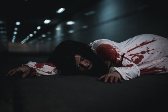 Horror bloodthirsty woman ghost horror she death and scary at dark night in tunnel, The girl was hit by a car and lying died on the road. full of blood left unattended, Happy halloween day festival