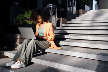 afro woman using laptop outdoor - 523441912