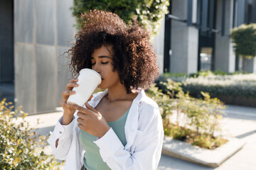 pretty young afro woman with coffee outdoors