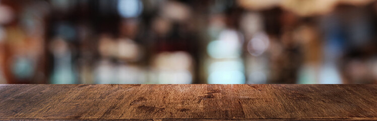 Empty dark wooden table in front of abstract blurred bokeh background of restaurant . can be used for display or montage your products.Mock up for space.