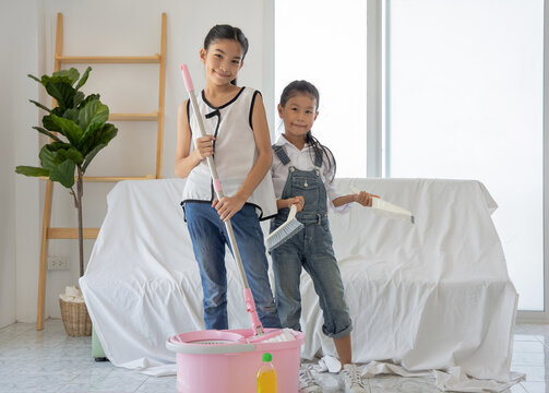 Two Cute Girls Helping Her Mom To Clean Up At Home.Sibling Sister Girl Ready To Help Her Mother Clean Up Room In Moving House Day.