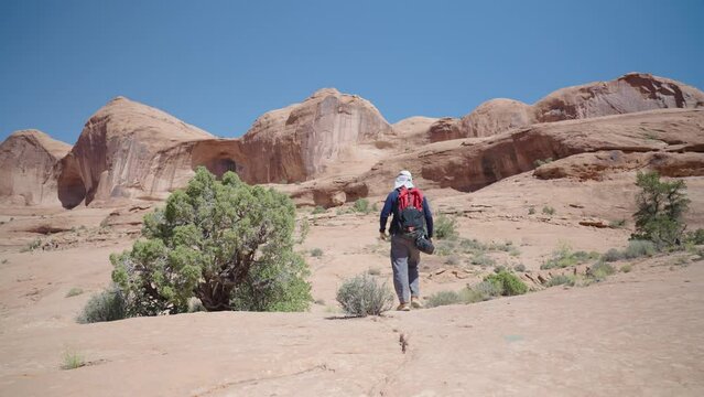 Hiker Walking towards Pinto Arch in Moab, United States