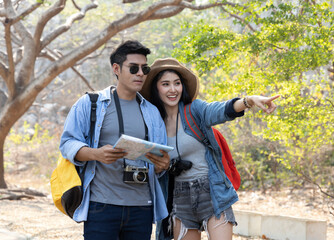Hikers using map , Young  asian couple navigating together smiling in park