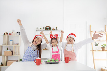 Happy asian family baking cooking cake together in kitchen on Christmas Day