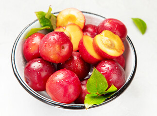 Plate of fresh ripe plums on table.