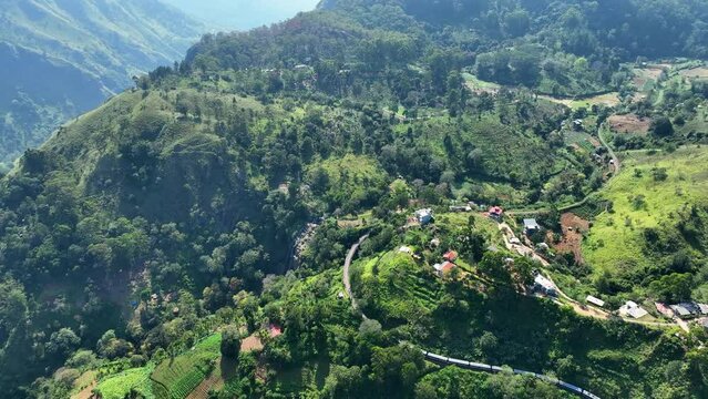 Aerial Panning Scenic Shot Of Train Moving On Green Mountain, Drone Flying During Sunny Day - Ella, Sri Lanka