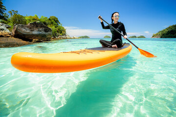 Asian woman relax on the beach with SUP BOARD